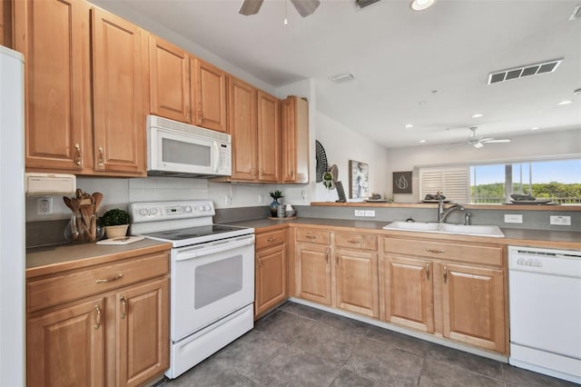 kitchen featuring visible vents, a sink, ceiling fan, white appliances, and a peninsula