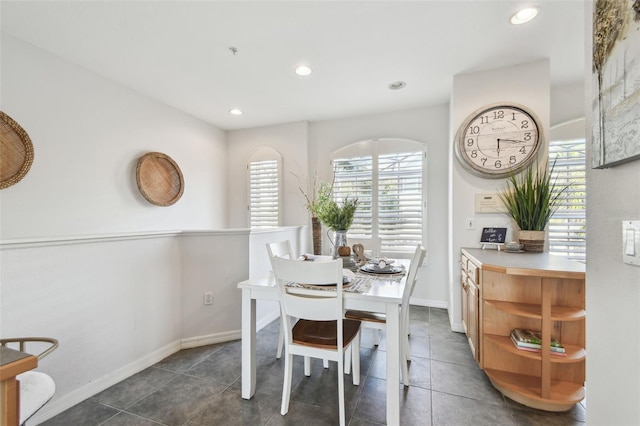 dining area featuring baseboards, dark tile patterned flooring, a wealth of natural light, and recessed lighting