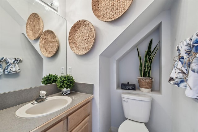 half bath featuring vanity and toilet