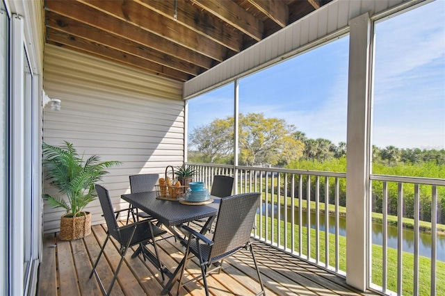sunroom / solarium featuring a water view and a healthy amount of sunlight