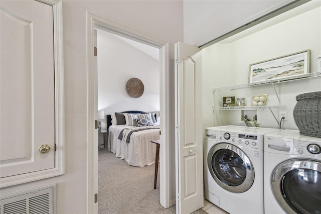 washroom featuring laundry area, visible vents, washer and clothes dryer, and light colored carpet