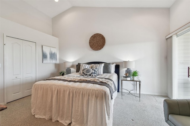 bedroom with a closet, light carpet, vaulted ceiling, and baseboards