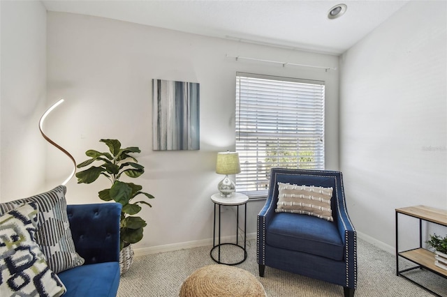 sitting room featuring light carpet and baseboards