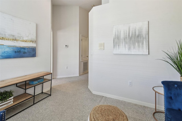hall with light carpet, visible vents, and baseboards