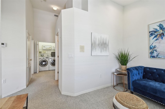 interior space featuring baseboards, light colored carpet, and independent washer and dryer