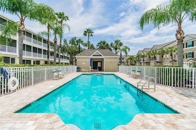 pool with a residential view, fence, and a patio