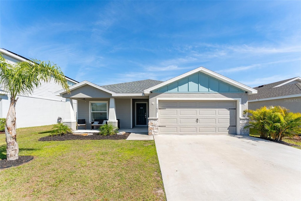 11627 Stone Pine St, Riverview, FL 33569 - view of front of house with a garage, driveway, board and batten siding, and a front yard