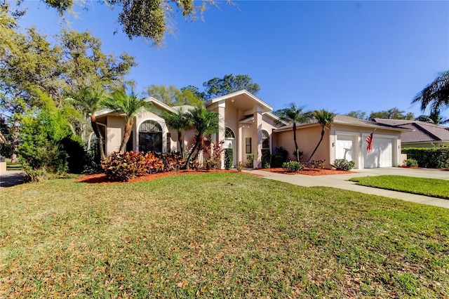 view of front of home featuring a garage, driveway, a front lawn, and stucco siding