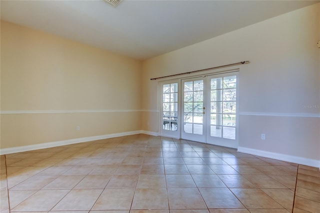 unfurnished room featuring light tile patterned floors, baseboards, and french doors