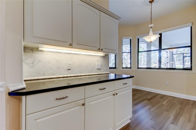 kitchen with tasteful backsplash, dark countertops, dark wood-style flooring, and a healthy amount of sunlight
