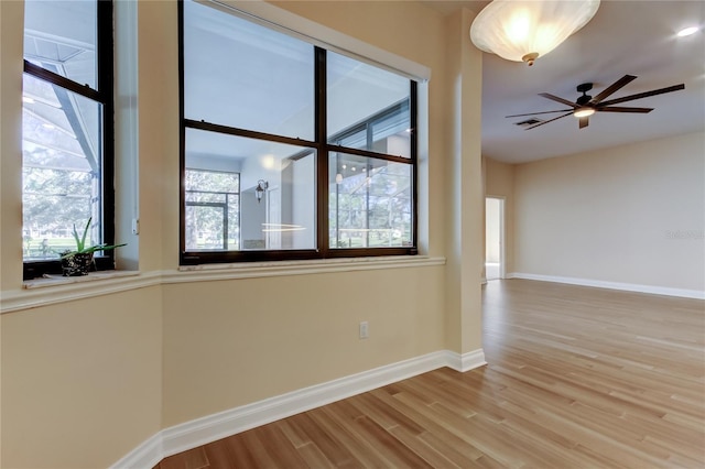 spare room with a ceiling fan, baseboards, and wood finished floors