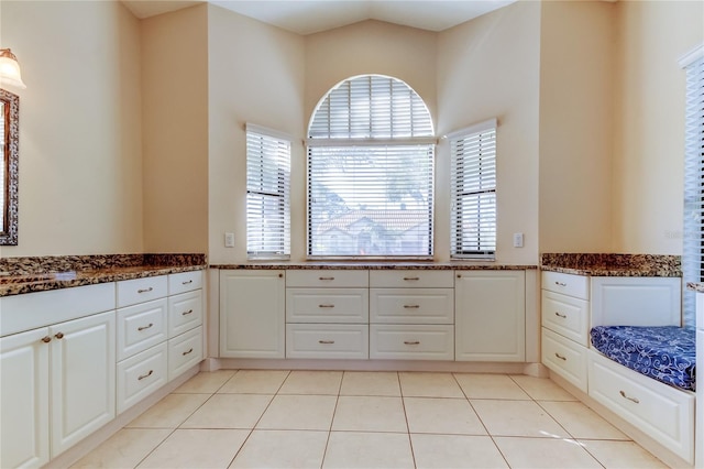 bathroom featuring lofted ceiling and tile patterned flooring