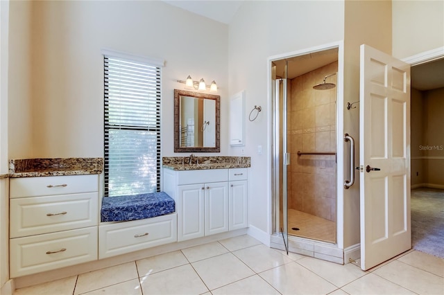 full bath with baseboards, a stall shower, vanity, and tile patterned floors