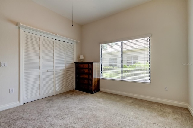 unfurnished bedroom with a closet, carpet, and baseboards