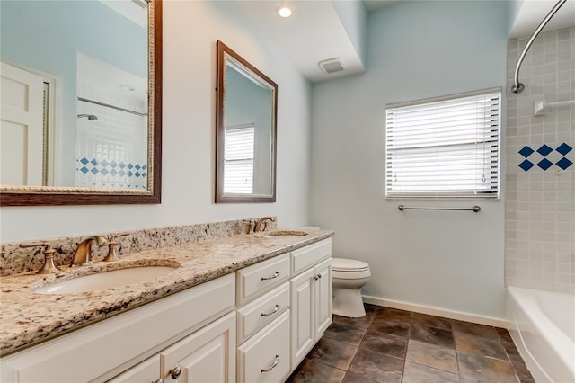 bathroom featuring a healthy amount of sunlight, a sink, and baseboards