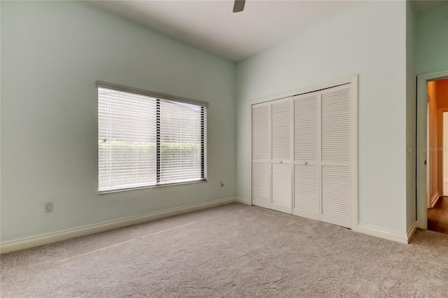 unfurnished bedroom with a ceiling fan, carpet, a closet, and baseboards