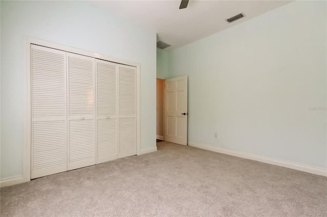 unfurnished bedroom featuring a closet, visible vents, light carpet, and baseboards