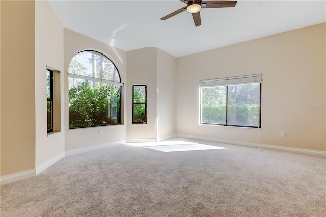 spare room featuring carpet floors, a ceiling fan, and baseboards