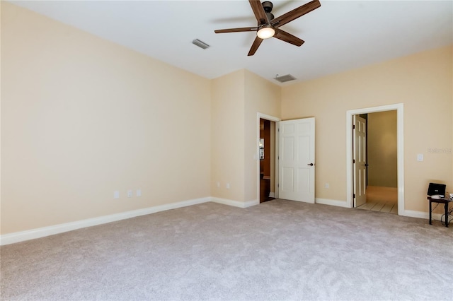unfurnished bedroom with baseboards, visible vents, ceiling fan, and light colored carpet