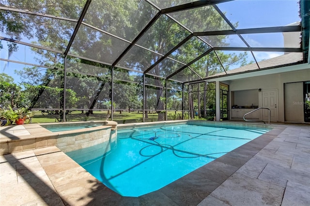 view of swimming pool featuring glass enclosure, a patio area, and a pool with connected hot tub