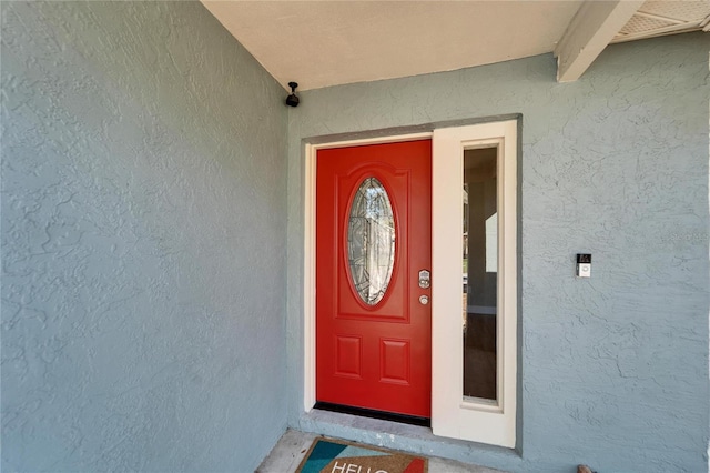 entrance to property featuring stucco siding