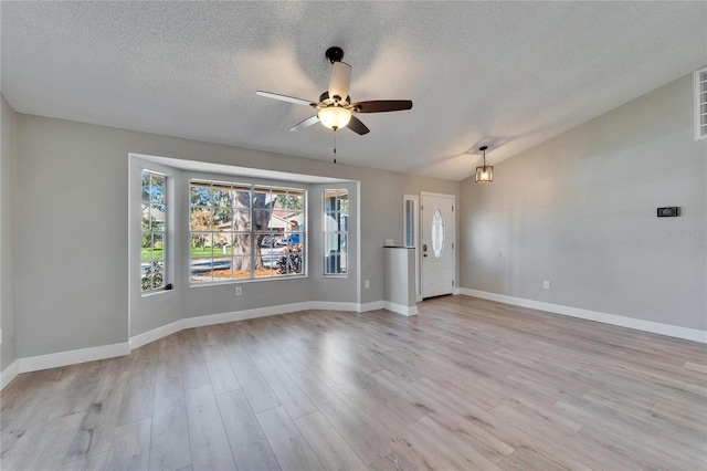 spare room featuring light wood-style flooring, baseboards, vaulted ceiling, and a ceiling fan