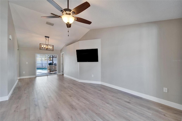 unfurnished living room with light wood finished floors, lofted ceiling, visible vents, baseboards, and ceiling fan with notable chandelier