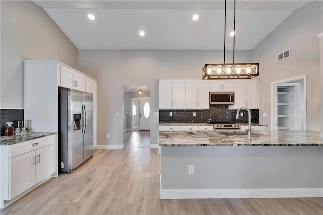 kitchen with hanging light fixtures, white cabinetry, visible vents, and stainless steel appliances