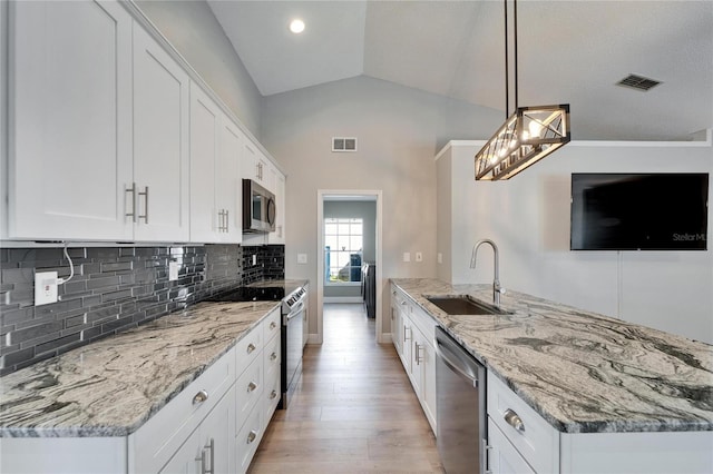 kitchen with appliances with stainless steel finishes, a sink, decorative light fixtures, and white cabinets