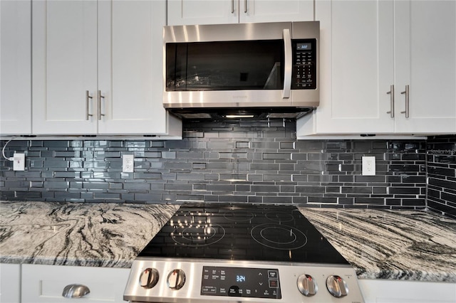 kitchen featuring light stone countertops, appliances with stainless steel finishes, and white cabinets