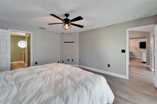 bedroom with visible vents, a ceiling fan, a textured ceiling, light wood-type flooring, and baseboards