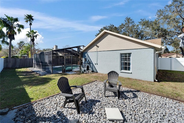 view of yard with a lanai, a fenced backyard, and a fenced in pool