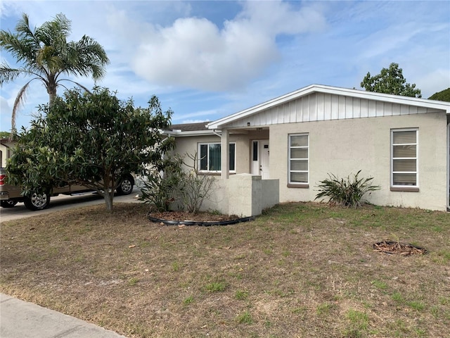 ranch-style home with a front lawn and stucco siding