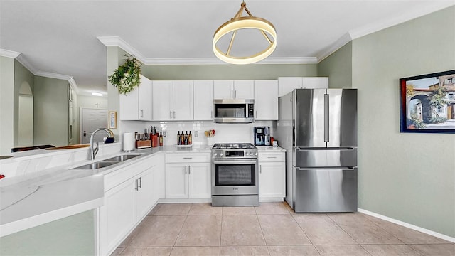 kitchen featuring stainless steel appliances, a sink, white cabinetry, and crown molding