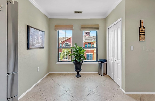 entryway featuring ornamental molding, visible vents, baseboards, and light tile patterned floors