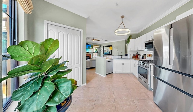 kitchen featuring a peninsula, hanging light fixtures, stainless steel appliances, light countertops, and white cabinetry