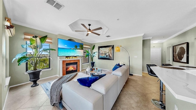 living room with ceiling fan, light tile patterned flooring, a glass covered fireplace, and visible vents