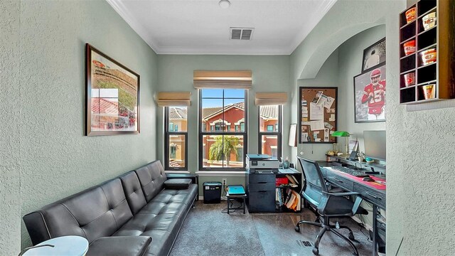 carpeted home office with a textured wall, visible vents, and crown molding