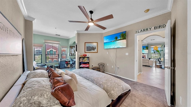 bedroom with light carpet, light tile patterned floors, baseboards, arched walkways, and ornamental molding