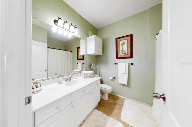 bathroom with toilet, vanity, and tile patterned floors