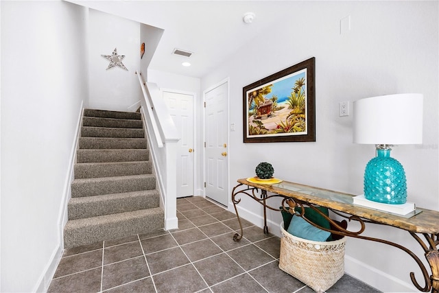 stairs featuring tile patterned flooring, visible vents, and baseboards