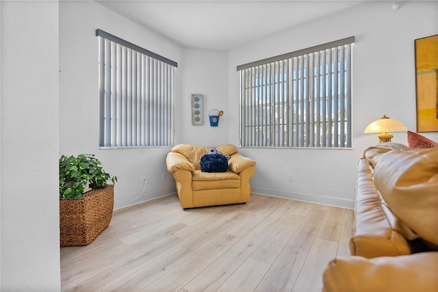 sitting room with baseboards and wood finished floors