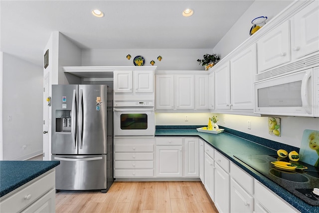 kitchen featuring recessed lighting, white appliances, white cabinetry, light wood-type flooring, and dark countertops