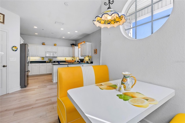 dining space with light wood-type flooring and recessed lighting