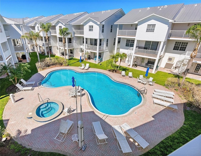 community pool with a patio area, a residential view, and a community hot tub