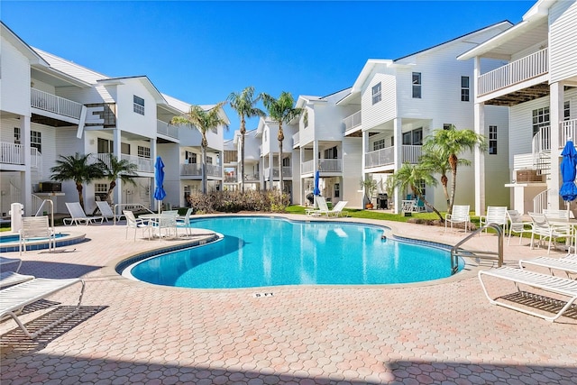 community pool featuring a residential view and a patio