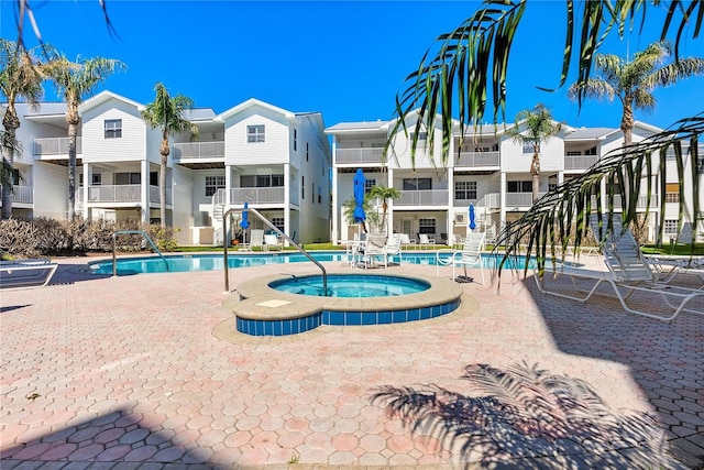 community pool with a residential view and a community hot tub