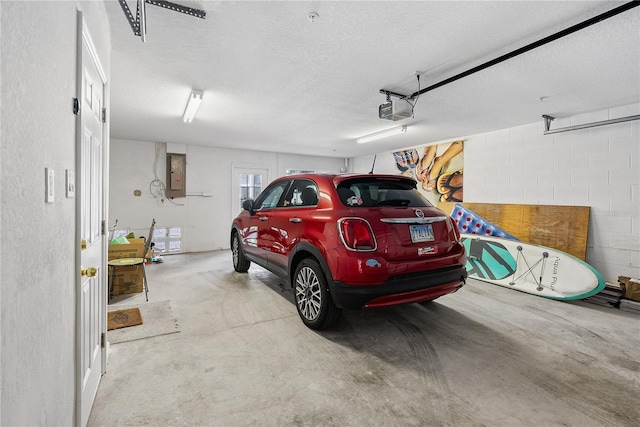 garage with a garage door opener, concrete block wall, and electric panel