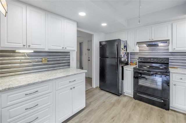 kitchen featuring under cabinet range hood, white cabinets, light wood-type flooring, black appliances, and tasteful backsplash