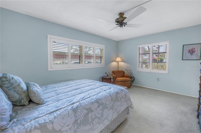 carpeted bedroom with a textured ceiling, ceiling fan, and baseboards